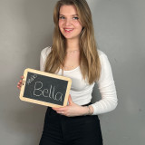 Person (Bild von Bella) mit kleiner Namenstafel in der Hand